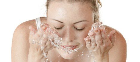 Mujer lavándose la cara después de maquillaje antibrillos