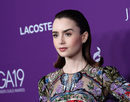 Lily Collins peina su cabello hacia atrás acabándolo en un rulo