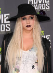 Kesha con el pelo suelto y sombrero