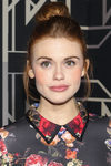 Holland Roden con moño alto y mechones sueltos