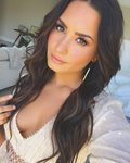 Demi Lovato con extensiones y maquillaje en tonos melocotón