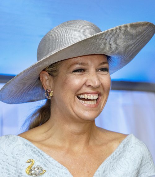 Reina Máxima de Holanda con pamela de rafia plateada y vestido azul en la inauguración de un centro de equinoterapia